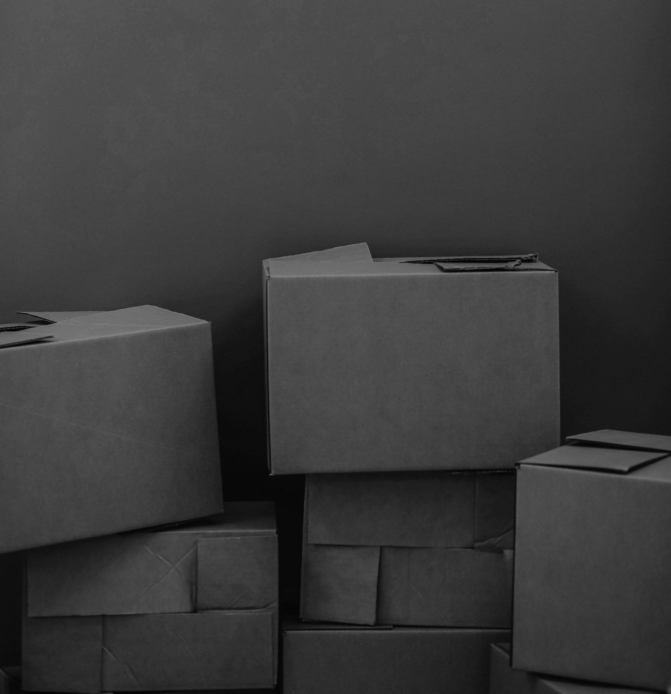 Cardboard boxes stacked against a dark wall